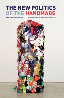 The book cover for The New Politics of the Handmade: Craft, Art and Design, edited by Anthea Black and Nicole Burisch, with title in navy blue and coral text, featuring an image of the artwork "Bale Variant no. 0020," by Shinique Smith that shows a very tall column of clothes knotted together with fabric strips, installed in a plain gallery space.